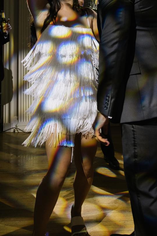 Elegant Moves: The Bride’s Joyful Dance Under the Party Lights